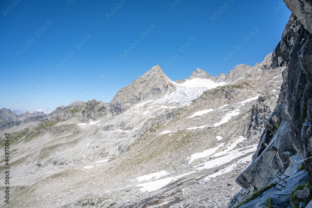 Summer alpine peaks with melting glacier on sunny day. Reichenspitze ridge in Zillertal Alps, Austria