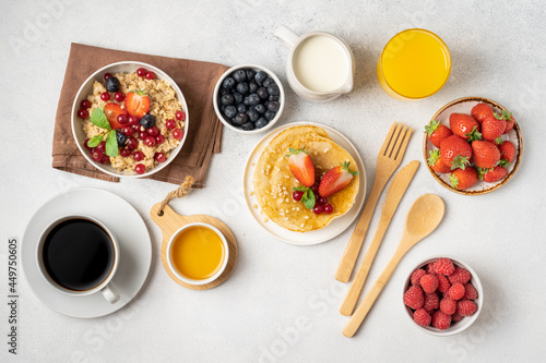 The continental breakfast is captured from above, top view. Coffee, croissants, granola, Belgian waffles, honey, jam. Layout with free text space, copy space