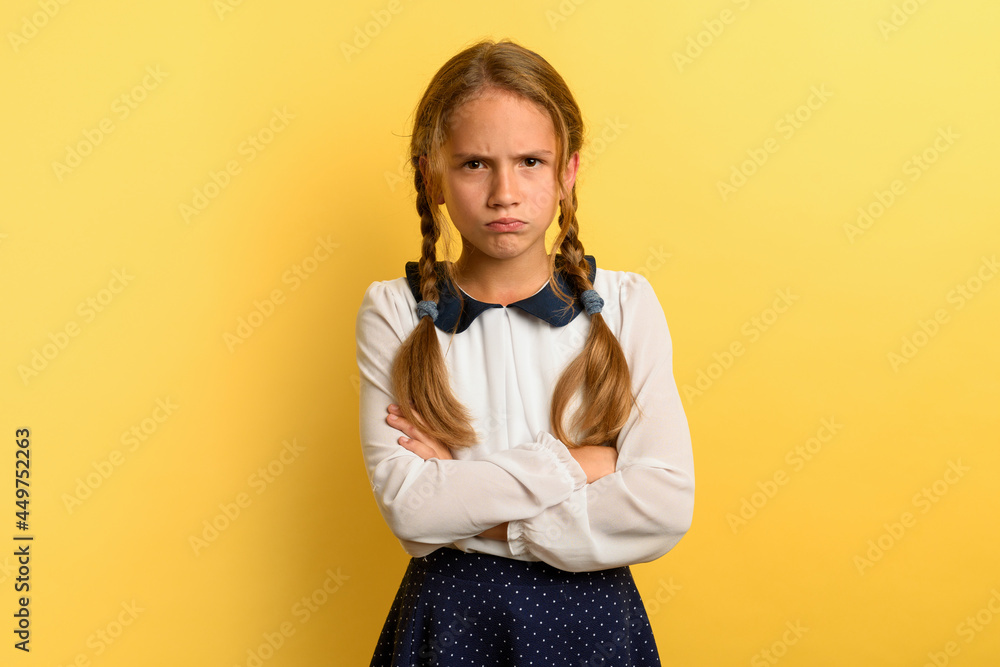 Young girl is unhappy and angry about something. yellow background Young girl is unhappy and angry about something. yellow background