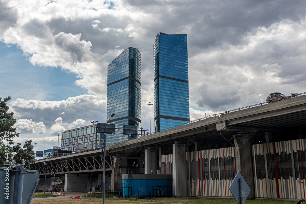Two skyscrapers and the Dorogomilovsky Bridge and against the background of a cloudy sky