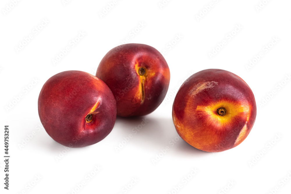 Three ripe nectarines with velvety skin on a white background
