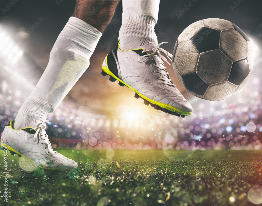 Close up of a soccer scene with player in a white uniform kicking the ball with power - obrazy, fototapety, plakaty 
