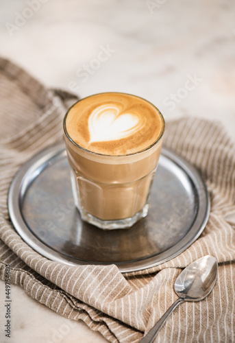 Glass of freshly brewed flat white coffee with heart shaped foam