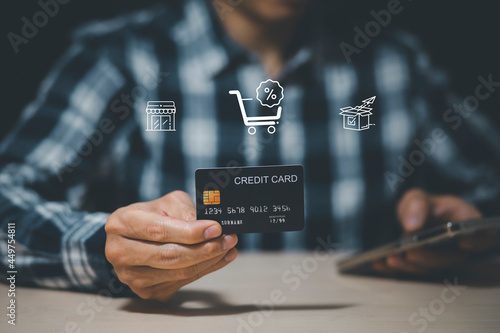 Businessman holding credit card for makes a purchase on the Internet on the laptop computer with credit card, online payment, shopping online, e-commerce, internet banking, spending money concept.