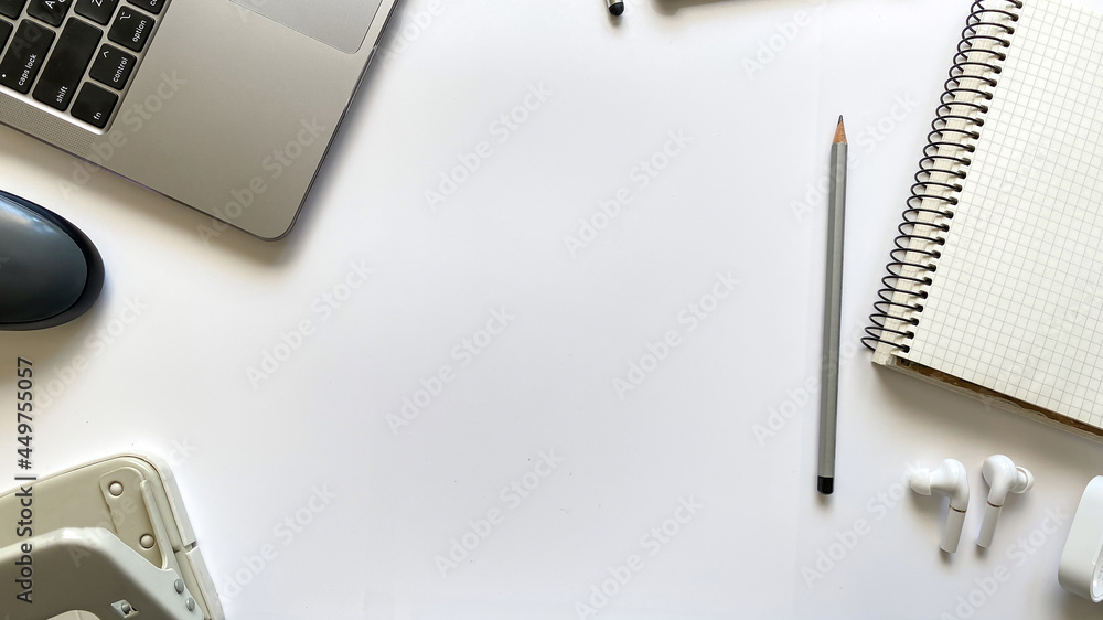 Layout on the topic of working process or education on a white background with notepad, pen, laptop, computer mouse, tablet, hole punch, headphones, pencil Layout on the topic of working process or education on a white background with notepad, pen, laptop, computer mouse, tablet, hole punch, headphones, pencil