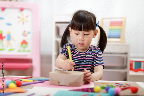 young girl decorating hand made craft for homeschooling