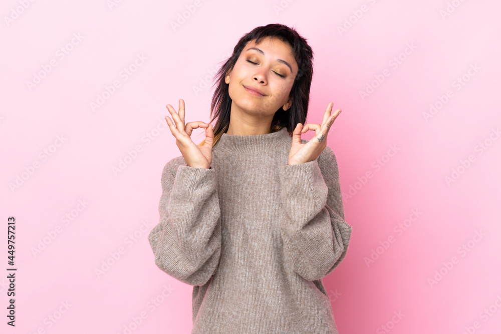 Young Uruguayan woman over isolated pink background in zen pose