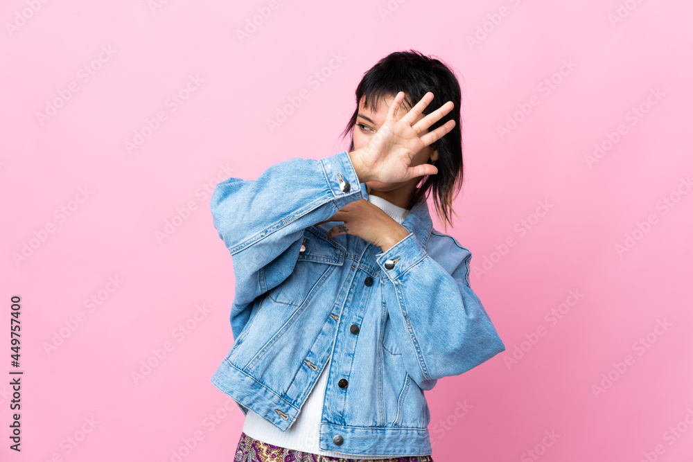 Young Uruguayan woman over isolated pink background nervous stretching hands to the front Young Uruguayan woman over isolated pink background nervous stretching hands to the front