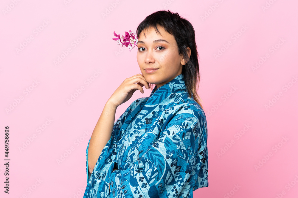 Young woman wearing kimono over isolated pink background Young woman wearing kimono over isolated pink background