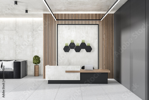 Modern concrete and wooden office lobby interior with reception desk, laptop, decorative plants and other items. 3D Rendering. photo