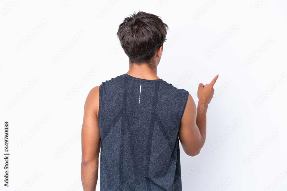 Young sport caucasian man isolated on white background pointing back with the index finger Young sport caucasian man isolated on white background pointing back with the index finger