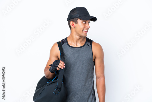 Young sport caucasian man with sport bag isolated on white background looking side