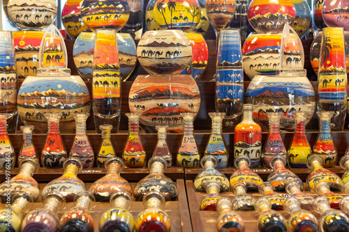 colorful arabic traditional sand art bottles displayed at souvenir shop in dubai, united arab emirates