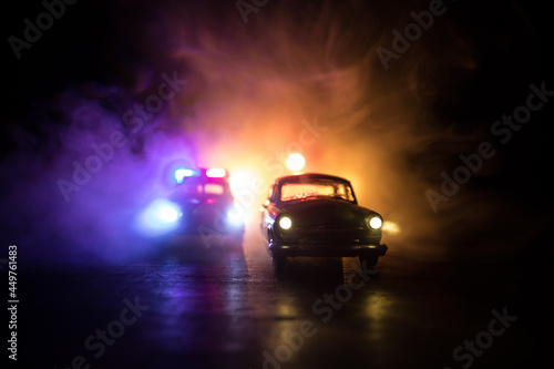 Police car chasing a car at night with fog background. 911 Emergency response police car speeding to scene of crime.