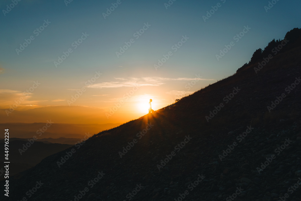 silhouette of man climbing mountain at sunset with magical sunset. effort, achievements silhouette of man climbing mountain at sunset with magical sunset. effort, achievements