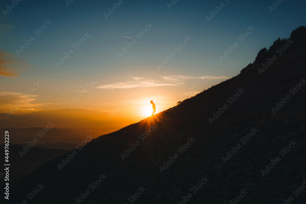 silhouette of man in a mountain in magical sunset. Adventure travel