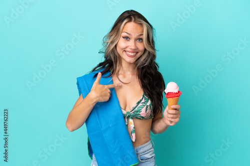 Teenager caucasian girl holding ice cream and towel isolated on blue background with surprise facial expression