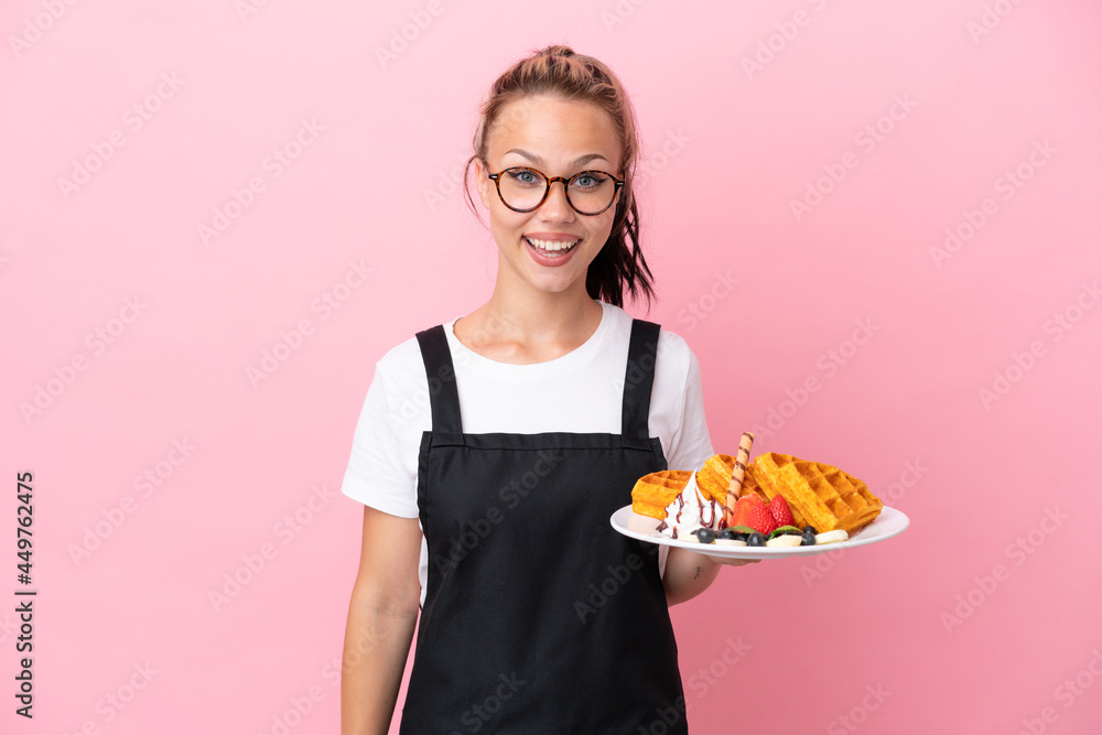 Restaurant waiter Russian girl holding waffles isolated on pink background with surprise facial expression