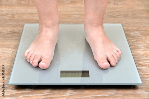 The feet of a boy on the scales.