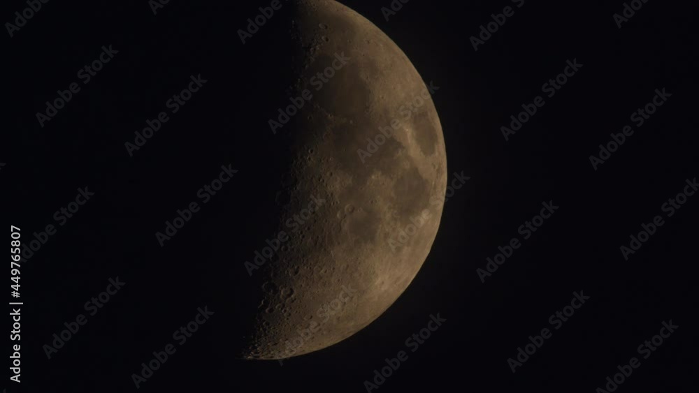 Half moon moving on the night sky dome with some clouds going across its silhouette in the perigeum. Half moon moving on the night sky dome with some clouds going across its silhouette in the perigeum.