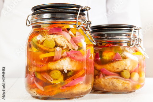 Fish marinade preparation steps: Layering cooked ingredients into a glass bottle to let marinade for one week