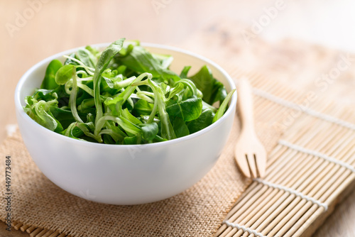 Fresh corn salad or lamb's lettuce in a bowl on wooden background, Fresh leaf vegetable mostly served as salad green