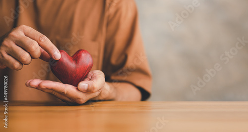 Fototapeta Naklejka Na Ścianę i Meble -  Male hands holding red heart, world mental health day and world heart day, Life and health insurance, CSR social responsibility, organ donation, ​concept of love