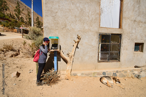 Tourist calling from a local telephone in Cochiguaz village, Elqui Valley, Chile photo