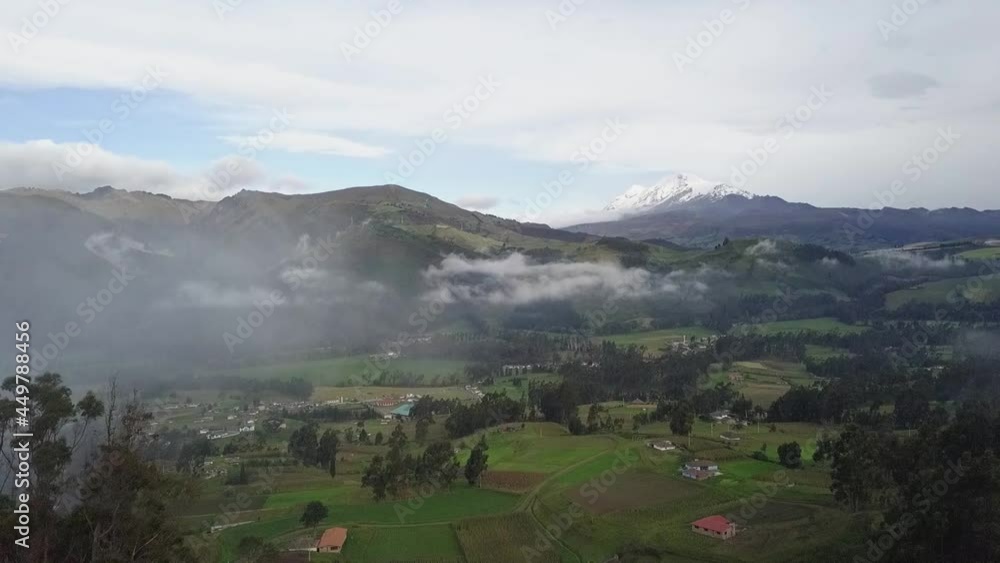 Foggy and cloudy valley landscape with small houses in aerial drone view Foggy and cloudy valley landscape with small houses in aerial drone view