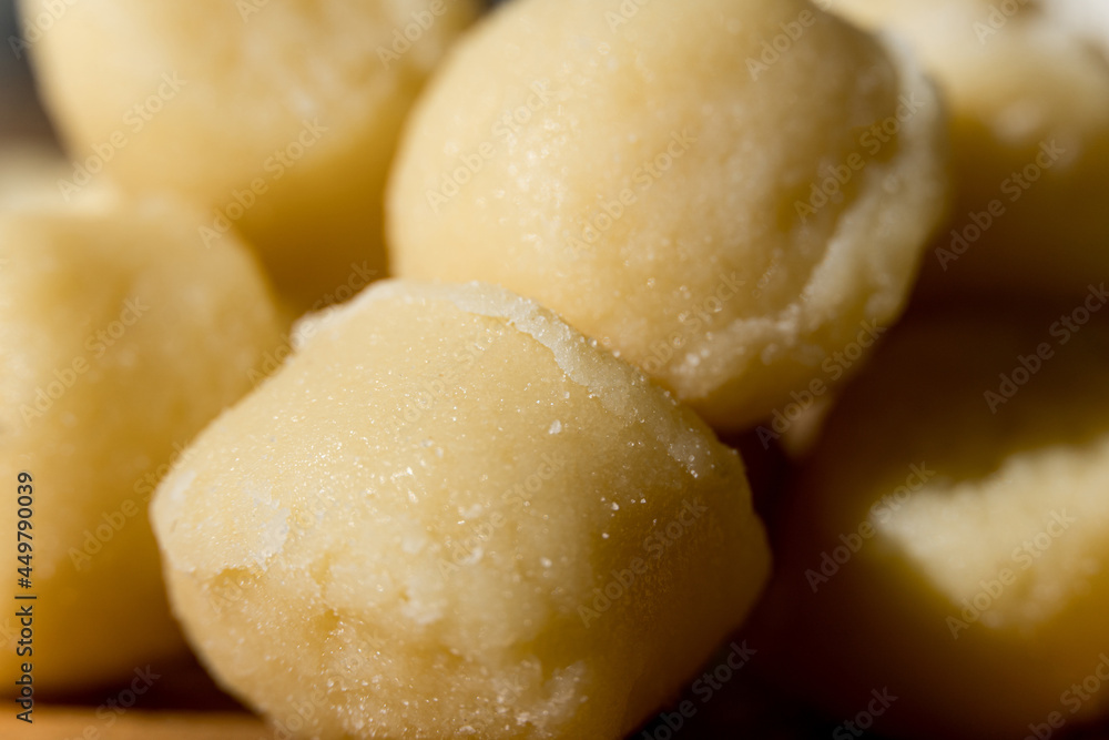 Gnocchi pasta pre-cooked on a wooden board with grated cheese and basil. Macro close up. Selective focus. Gnocchi pasta pre-cooked on a wooden board with grated cheese and basil. Macro close up. Selective focus.