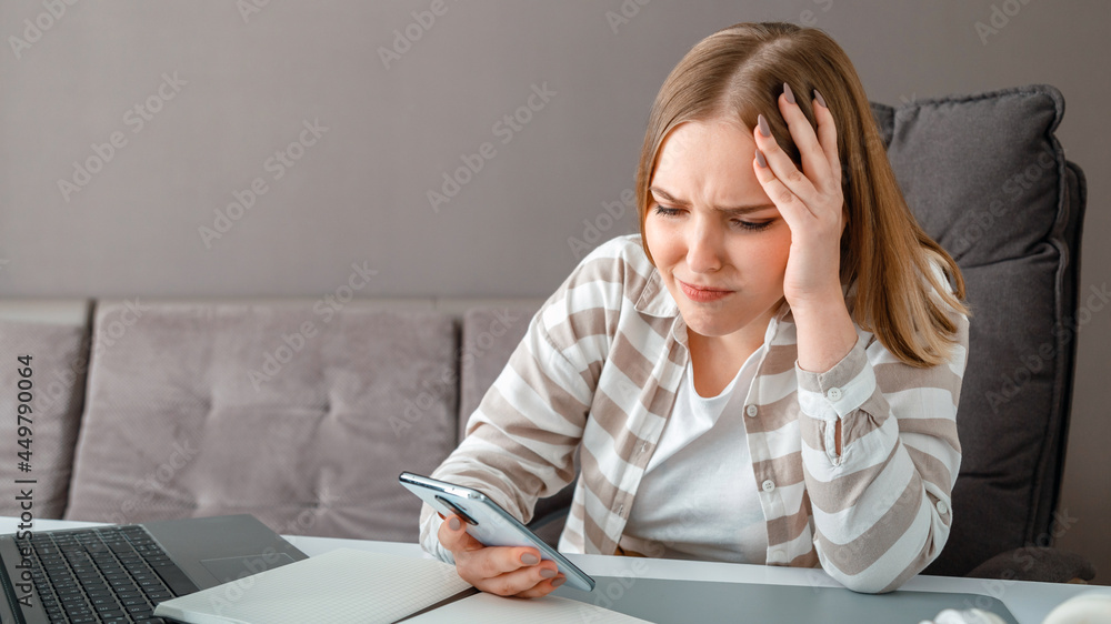 Young woman upset under stress. Confused woman holding head received bad news via smartphone at work. Teen girl looks at smartphone screen during negative emotions depression. Long web banner Young woman upset under stress. Confused woman holding head received bad news via smartphone at work. Teen girl looks at smartphone screen during negative emotions depression. Long web banner