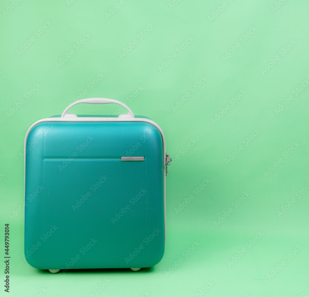 Green luggage for travel on green background Green luggage for travel on green background