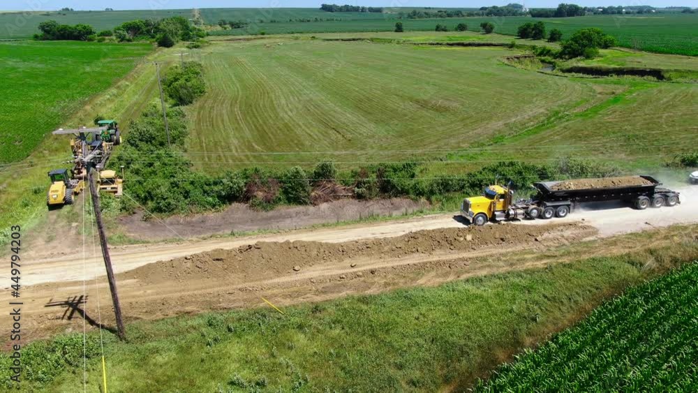 Large tractor with side dump trailer loaded with gravel on its way to deliver gravel to road construction site. Aerial. Large tractor with side dump trailer loaded with gravel on its way to deliver gravel to road construction site. Aerial.