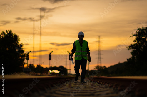 Engineer under inspection and checking construction process railway switch and checking work on railroad station .Engineer wearing safety uniform and safety helmet in work. 