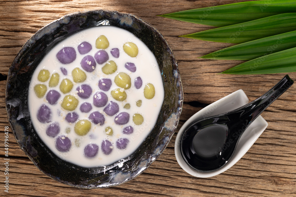 Bualoy, Bua Loy, Bualoi, Bua Loi, Thai dessert, sticky rice dumplings in sweet coconut milk, purple color from taro, green color from pandan leaf on rustic natural wood texture background, top view Bualoy, Bua Loy, Bualoi, Bua Loi, Thai dessert, sticky rice dumplings in sweet coconut milk, purple color from taro, green color from pandan leaf on rustic natural wood texture background, top view
