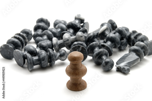фотографія Chess pieces, defeated black pieces laying down with standing white piece