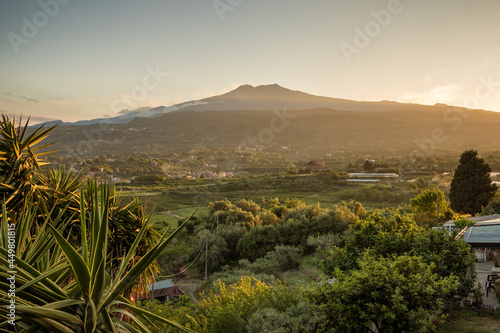 Sicilian rural landscape with Etna volcano eruption at sunset in Sicily