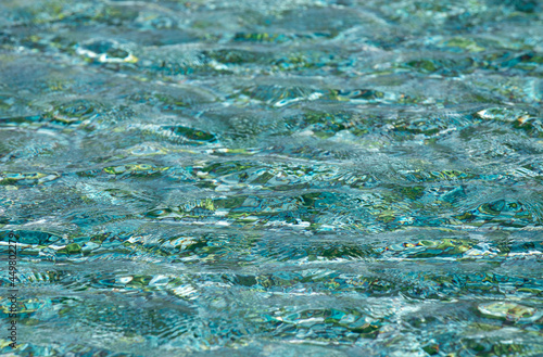 small waves on the surface of a turquoise water