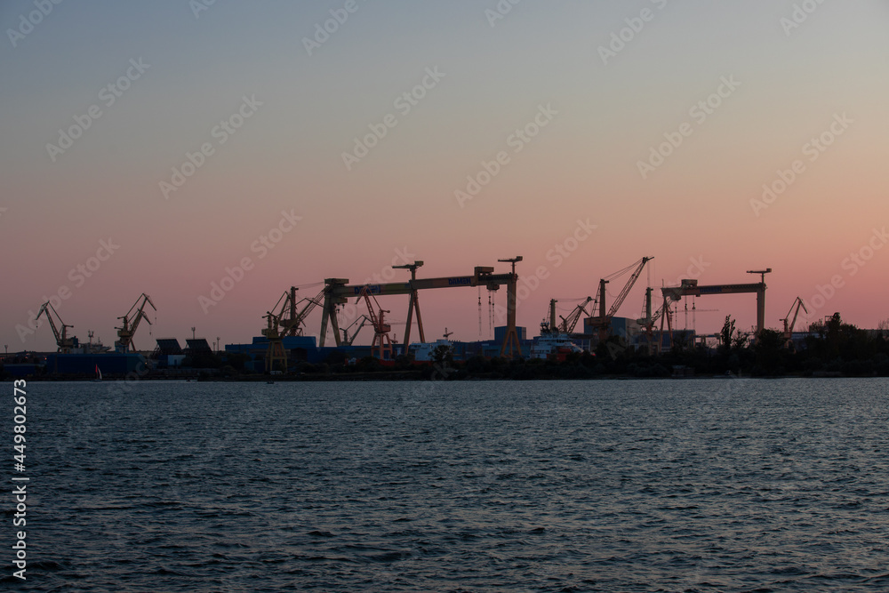 silhouettes of harbor cranes in the evening in Mangalia city - Romania
