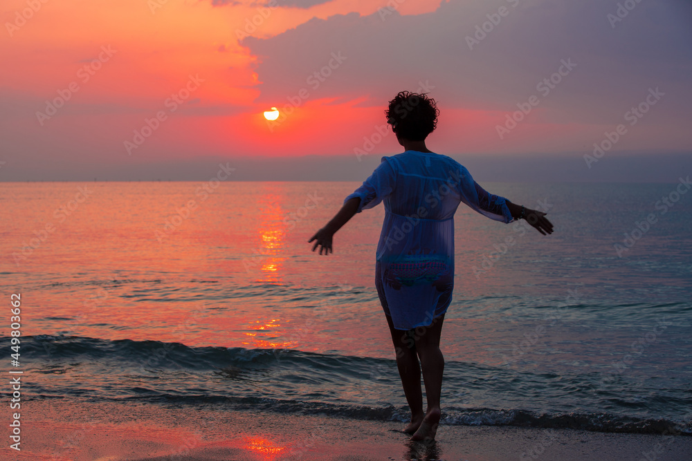 a woman on the beach at sunrise a woman on the beach at sunrise