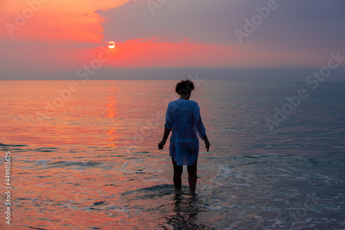 a woman on the beach at sunset