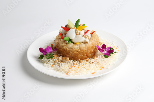 deep fried crispy taro yam ring with stir fried scallop and vegetables in white background asian halal menu