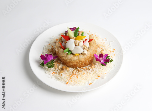 deep fried crispy taro yam ring with stir fried scallop and vegetables in white background asian halal menu