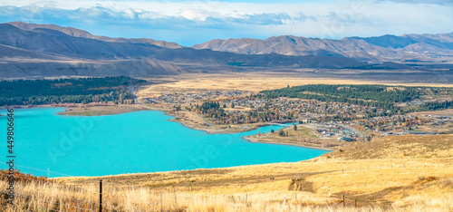 aerial view of a turquoise Lake Tekapo and a lovely Tekapo Town in Autumn, view from Mount John in Mackenzie Region, south island of New Zealand photo
