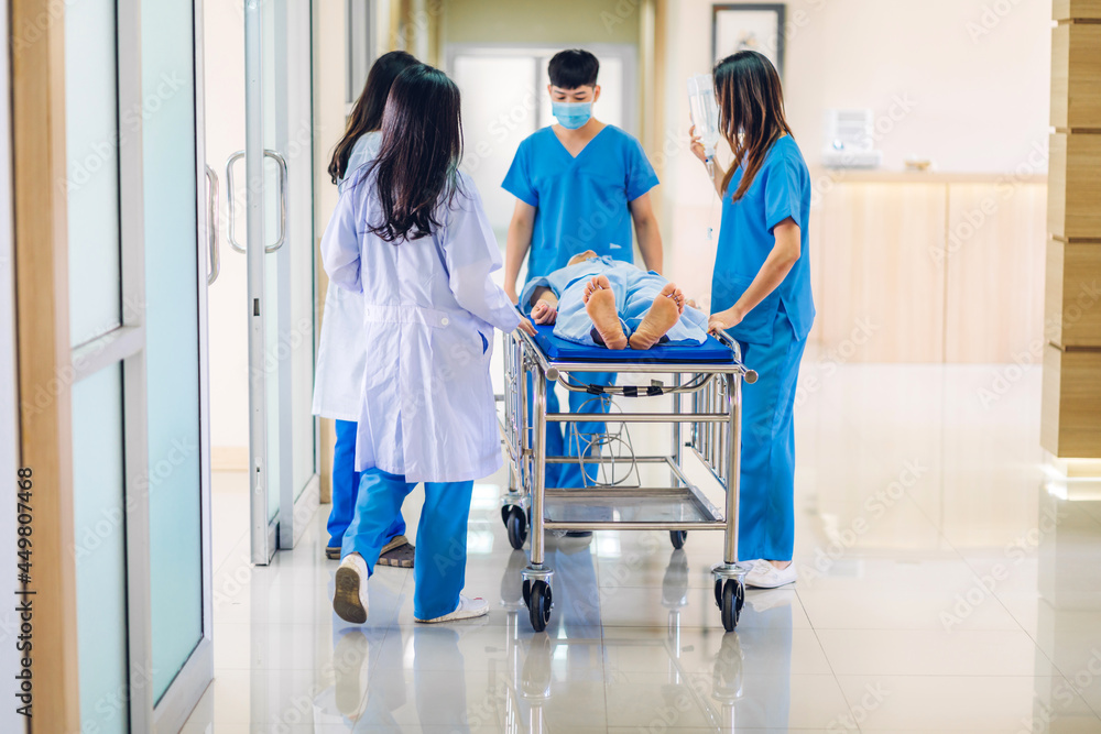 Group of professional medical doctor team and assistant with stethoscope in uniform taking seriously injured patient to operation emergency theatre room in hospital.health medical care concept Group of professional medical doctor team and assistant with stethoscope in uniform taking seriously injured patient to operation emergency theatre room in hospital.health medical care concept