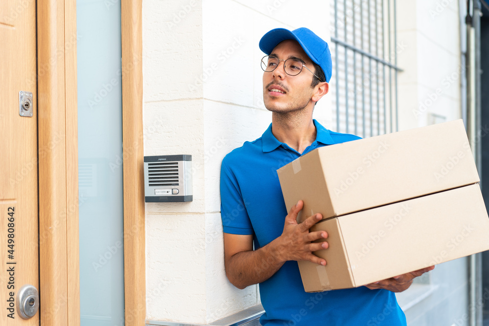 Young delivery man at outdoors holding boxes Young delivery man at outdoors holding boxes