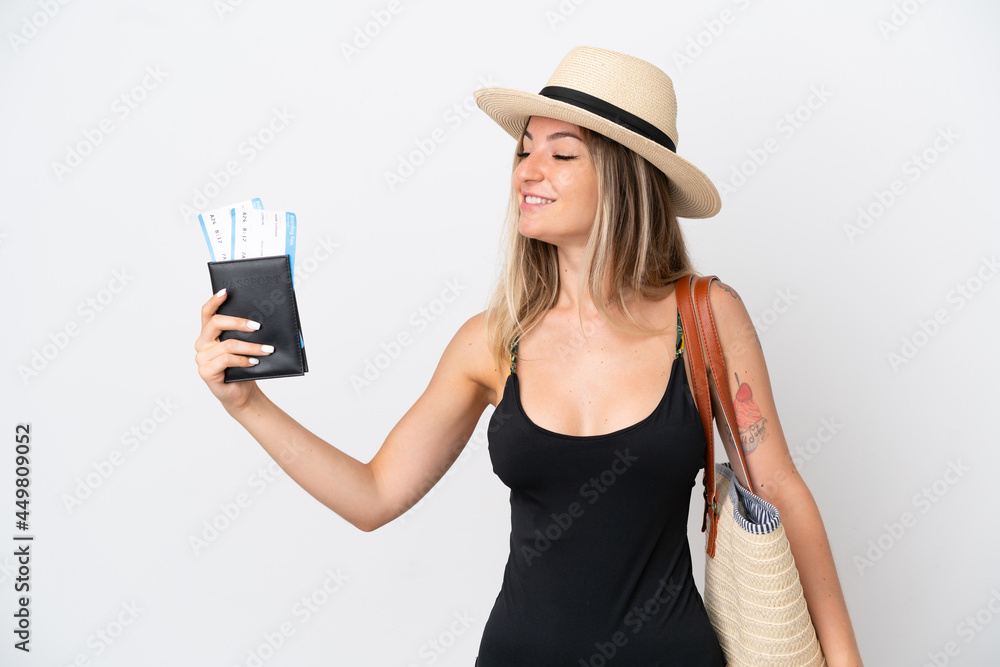 Young woman in swimsuit holding a passport isolated on white background with happy expression Young woman in swimsuit holding a passport isolated on white background with happy expression