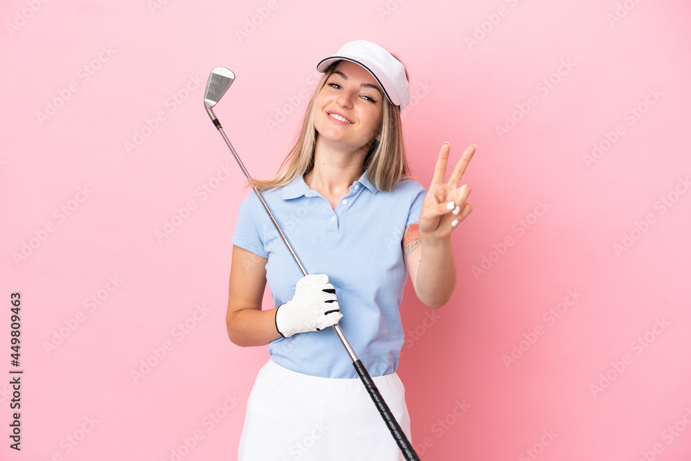 Young golfer player woman isolated on pink background smiling and showing victory sign Young golfer player woman isolated on pink background smiling and showing victory sign