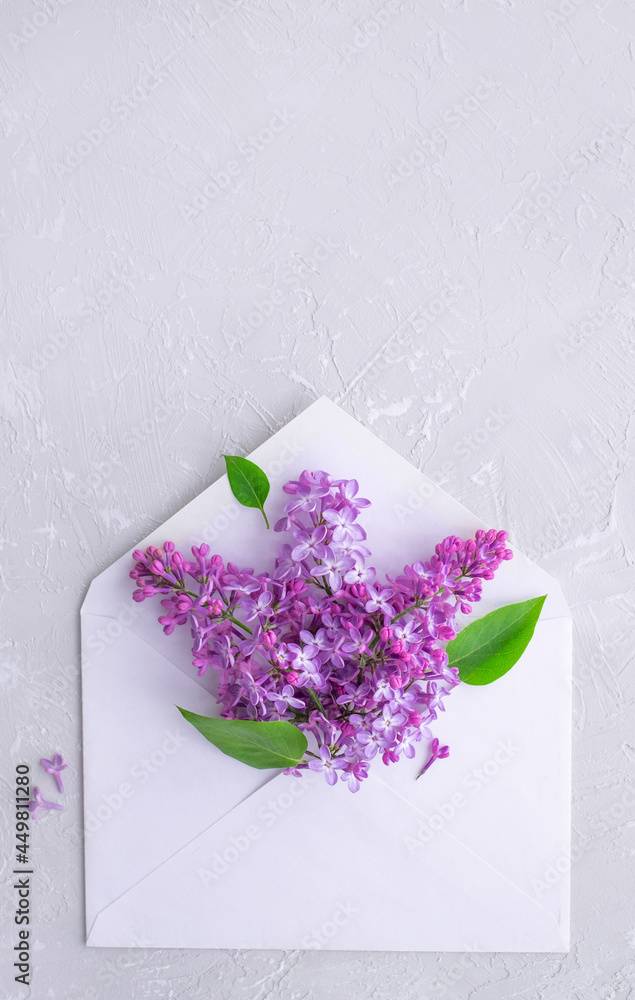 Obraz premium Mother's day. Spring lilac flowers blooming from white envelope. Birthday, Women's, Valentine. Flat lay, minimal.