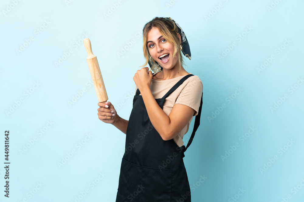 Young blonde Uruguayan cooking woman isolated on blue background celebrating a victory Young blonde Uruguayan cooking woman isolated on blue background celebrating a victory